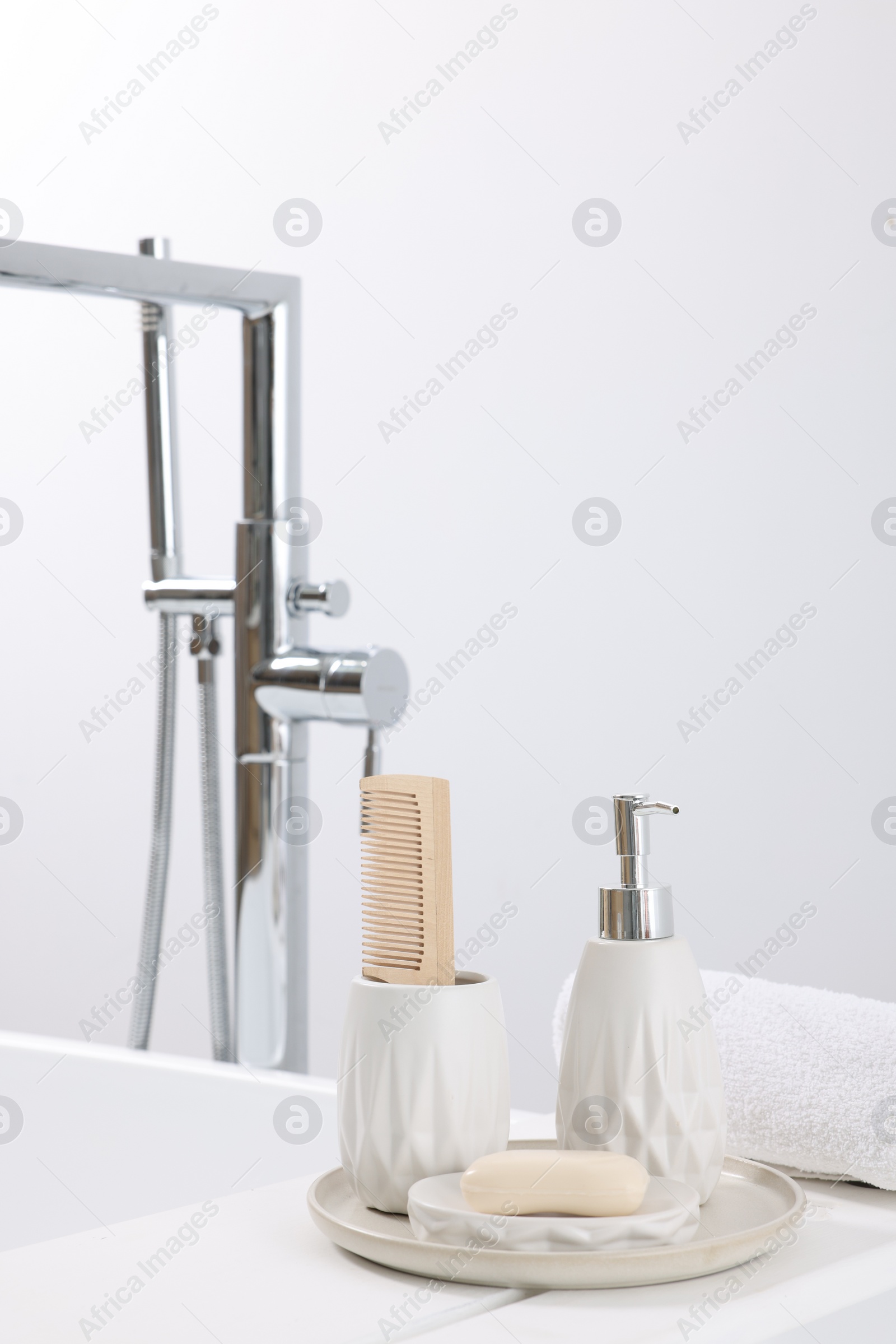 Photo of Different personal care products and accessories on bath tub in bathroom