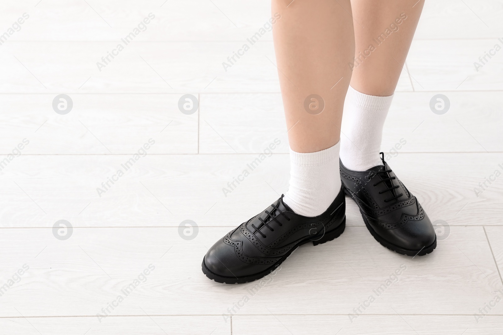 Photo of Girl in stylish school uniform indoors, focus on legs