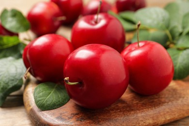Delicious ripe cherry plums with leaves on table, closeup
