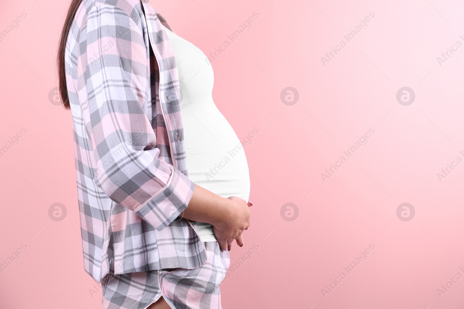 Photo of Young pregnant woman against color background, closeup. Space for text