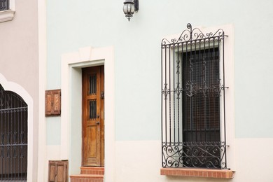 Photo of Light blue building with wooden door and window