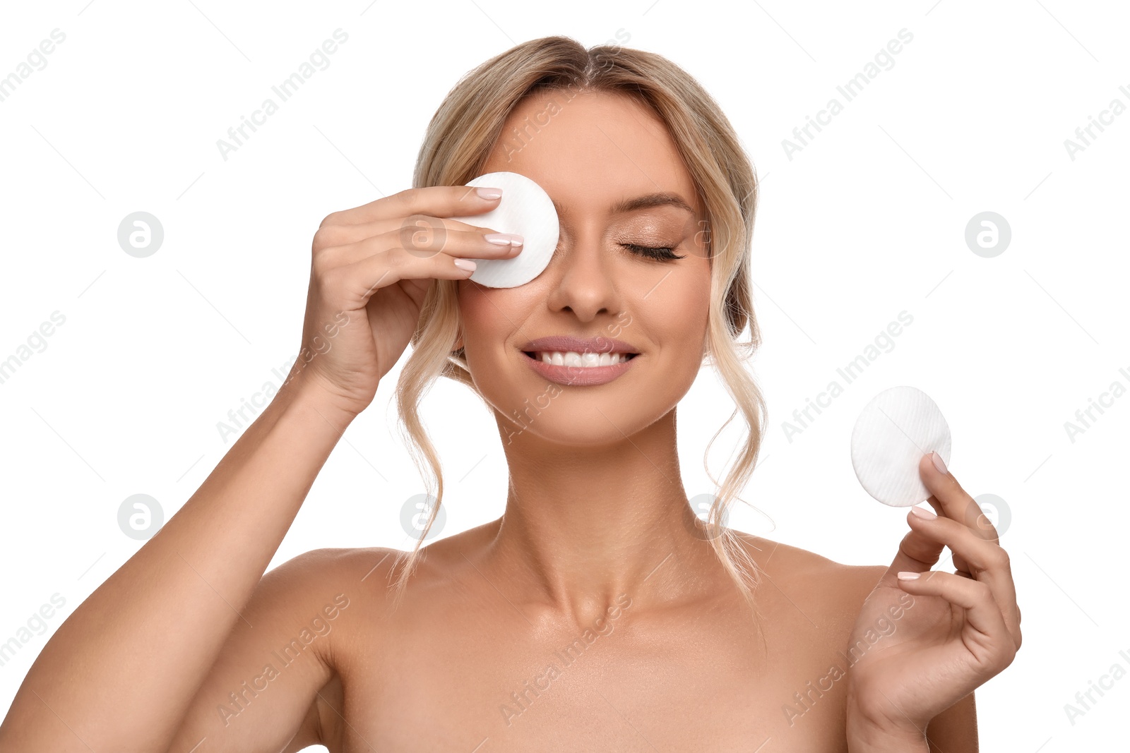 Photo of Smiling woman removing makeup with cotton pads on white background