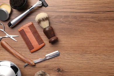 Photo of Moustache and beard styling tools on wooden background, flat lay. Space for text