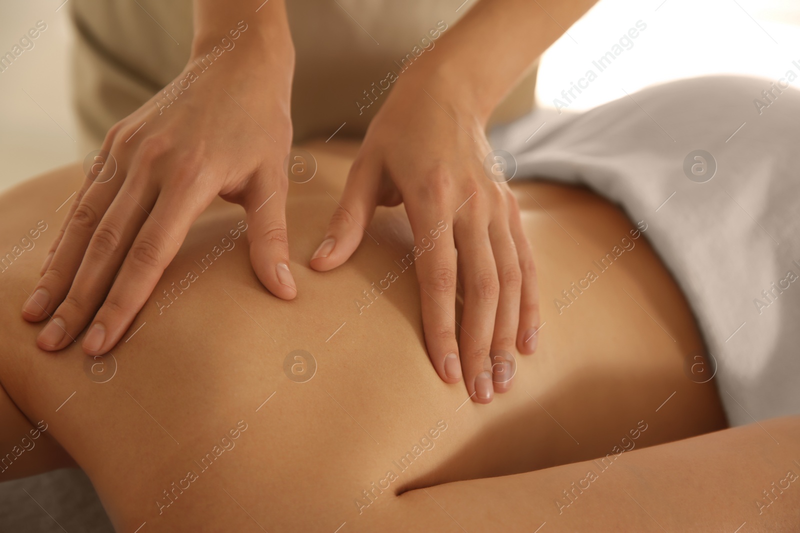 Photo of Young woman receiving back massage in spa salon, closeup