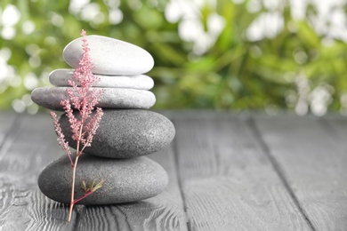 Photo of Spa stones on table against blurred background. Space for text