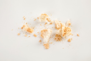 Scattered bread crumbs on white background, top view