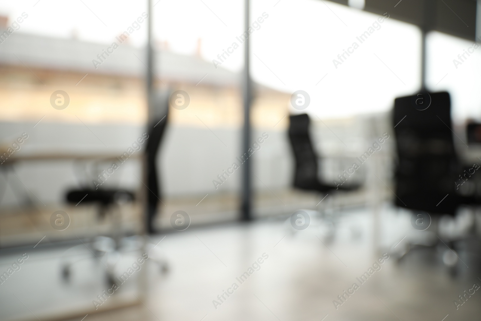 Photo of Blurred view of cozy workspaces with tables and chairs in office