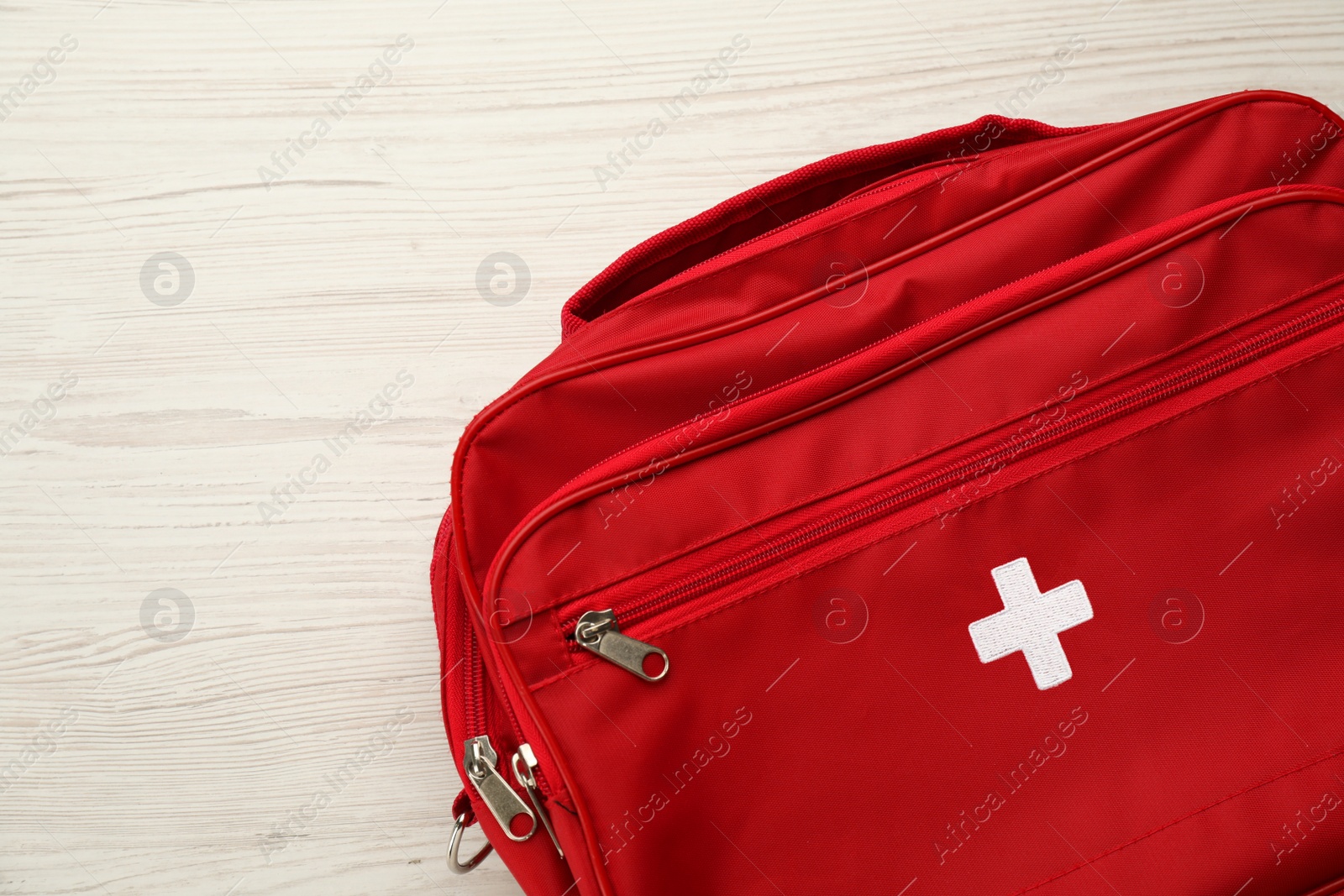 Photo of First aid kit bag on white wooden table, closeup