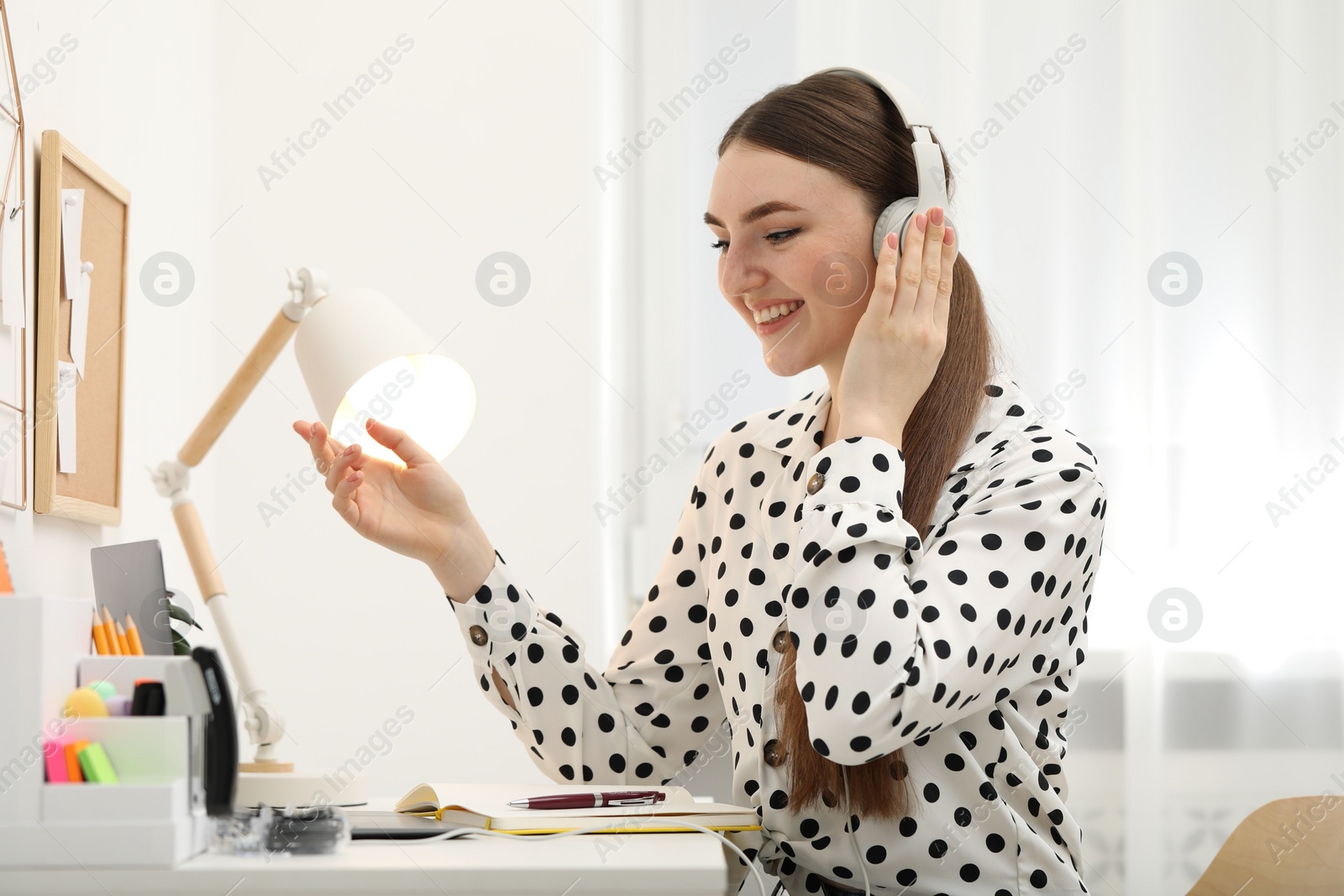 Photo of E-learning. Young woman using laptop during online lesson at table indoors