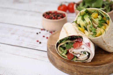 Photo of Delicious sandwich wraps with fresh vegetables and peppercorns on white wooden table, closeup. Space for text