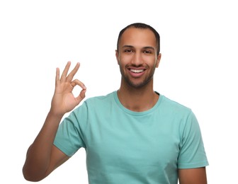 Photo of Smiling man with healthy clean teeth showing ok gesture on white background