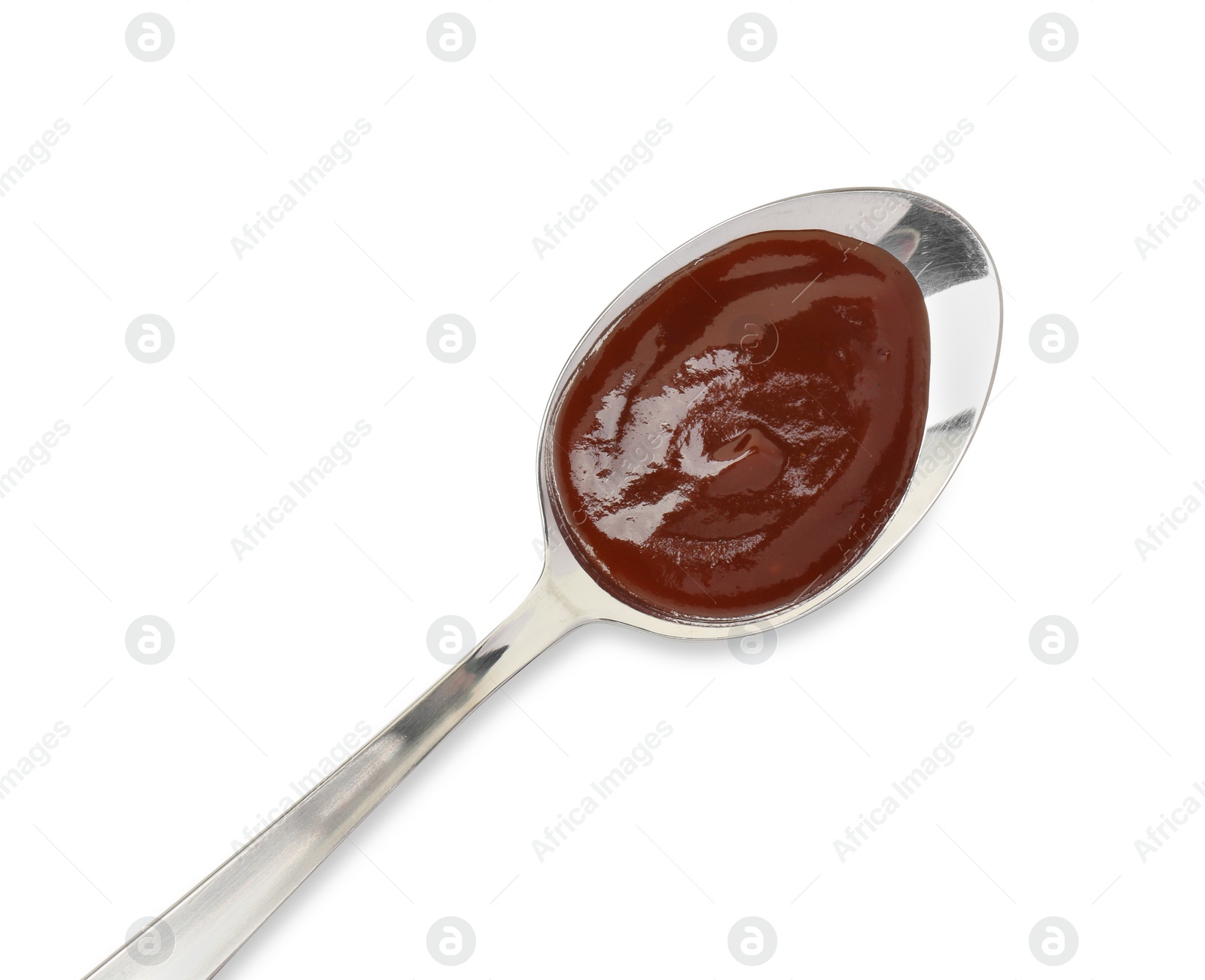 Photo of Tasty barbecue sauce in spoon isolated on white, top view