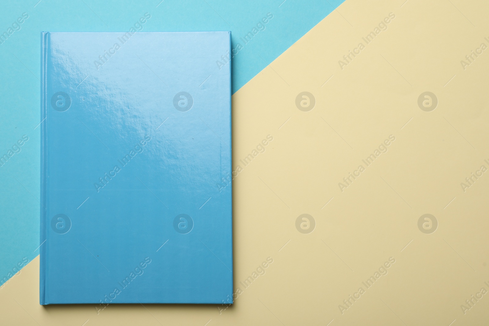 Photo of New light blue planner on color background, top view. Space for text