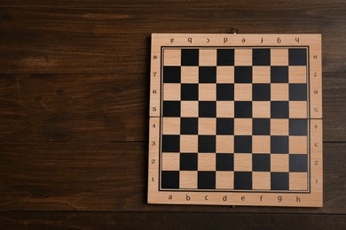 Photo of Game checkerboard on wooden table, top view. Space for text