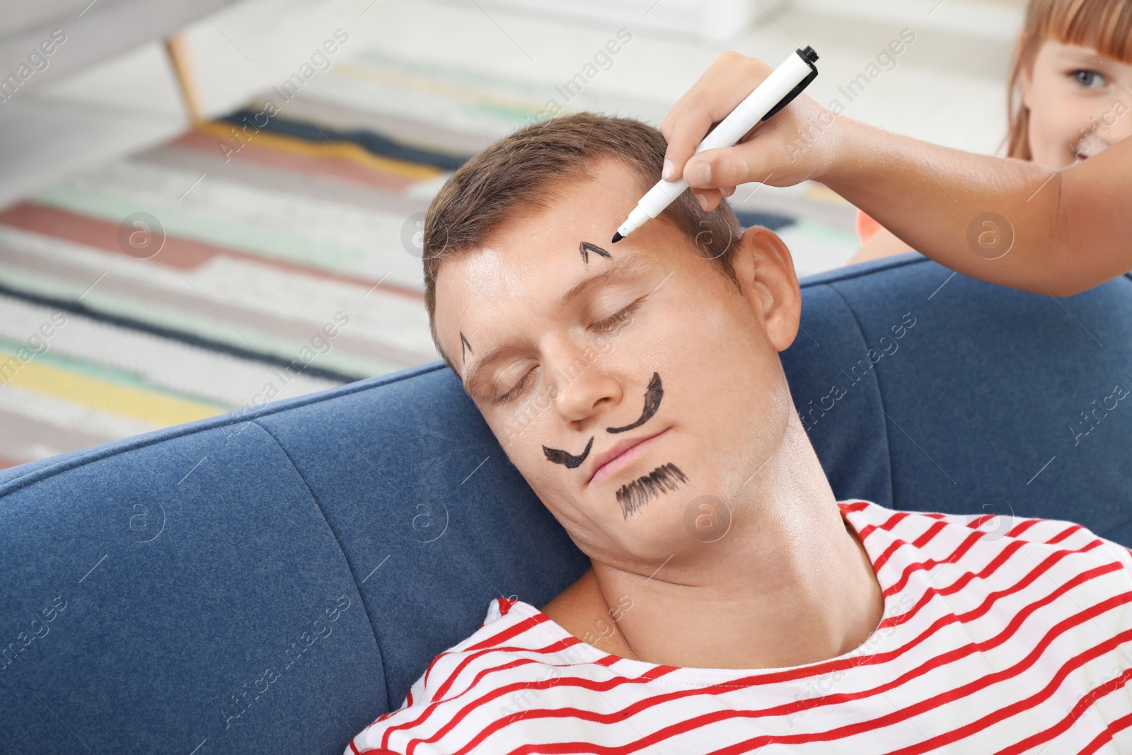 Photo of Child painting father's face while he sleeping on April Fool's Day