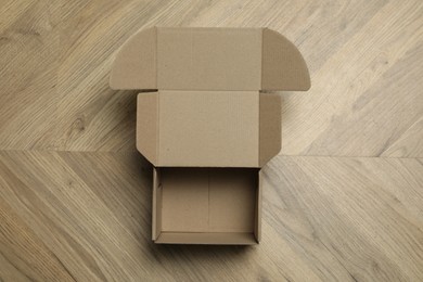 Empty open cardboard box on floor, top view