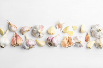 Photo of Fresh organic garlic on white wooden table, flat lay