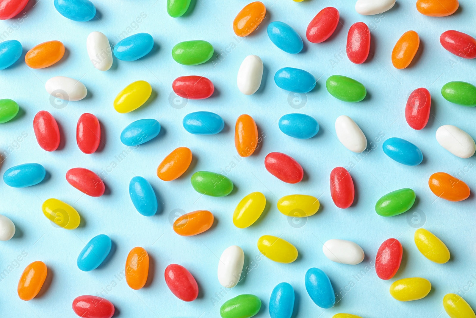 Photo of Flat lay composition with delicious jelly beans on color background