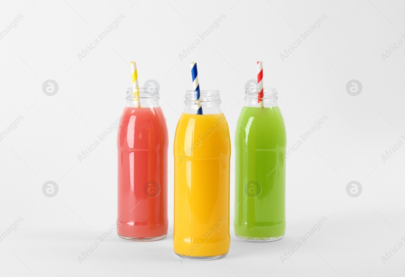 Photo of Bottles with delicious colorful juices on white background