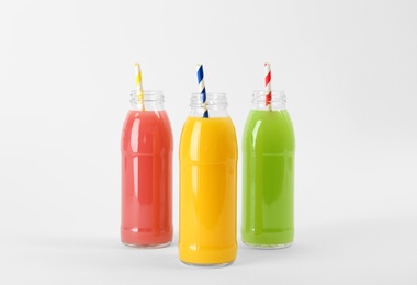 Photo of Bottles with delicious colorful juices on white background