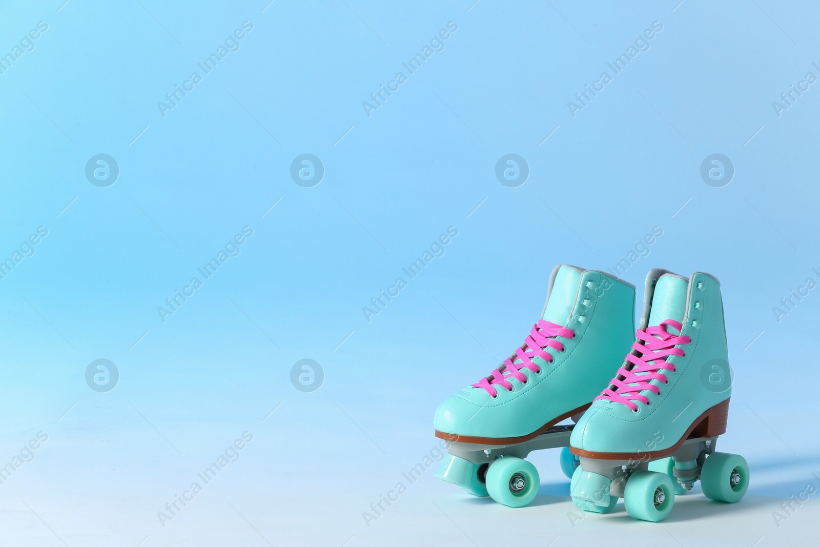 Photo of Pair of vintage roller skates on color background. Space for text