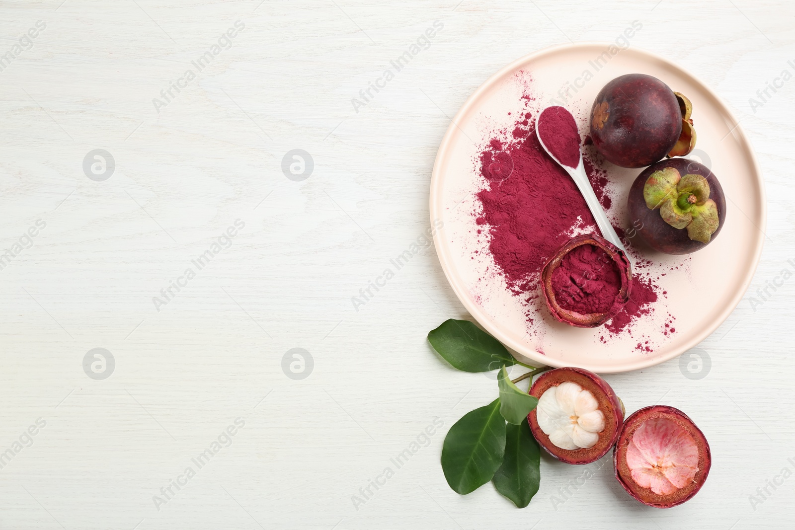 Photo of Purple mangosteen powder and fruits on white wooden table, flat lay. Space for text