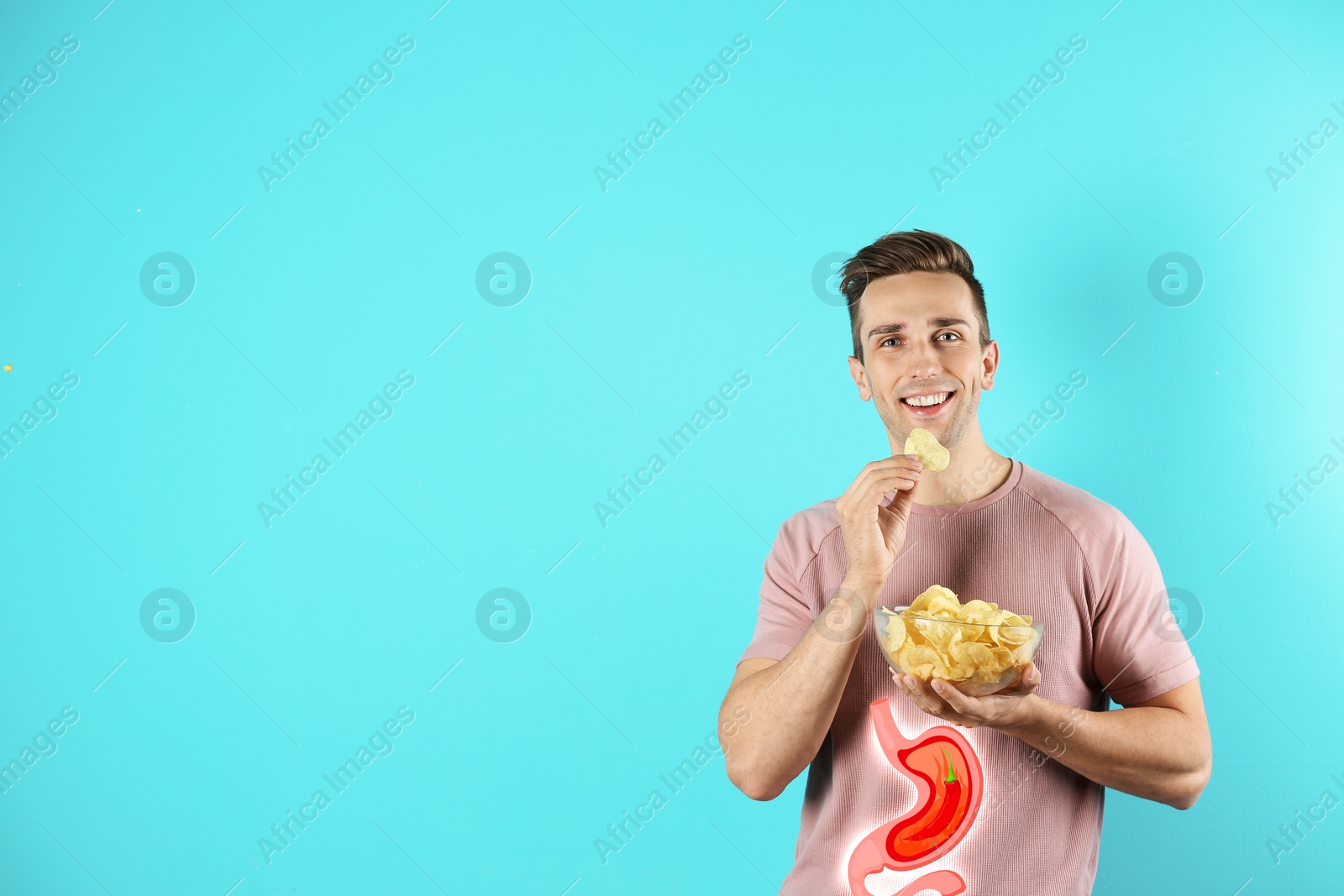 Image of Improper nutrition can lead to heartburn or other gastrointestinal problems. Man eating potato chips on light blue background, space for text. Illustration of stomach with hot chili pepper as acid indigestion