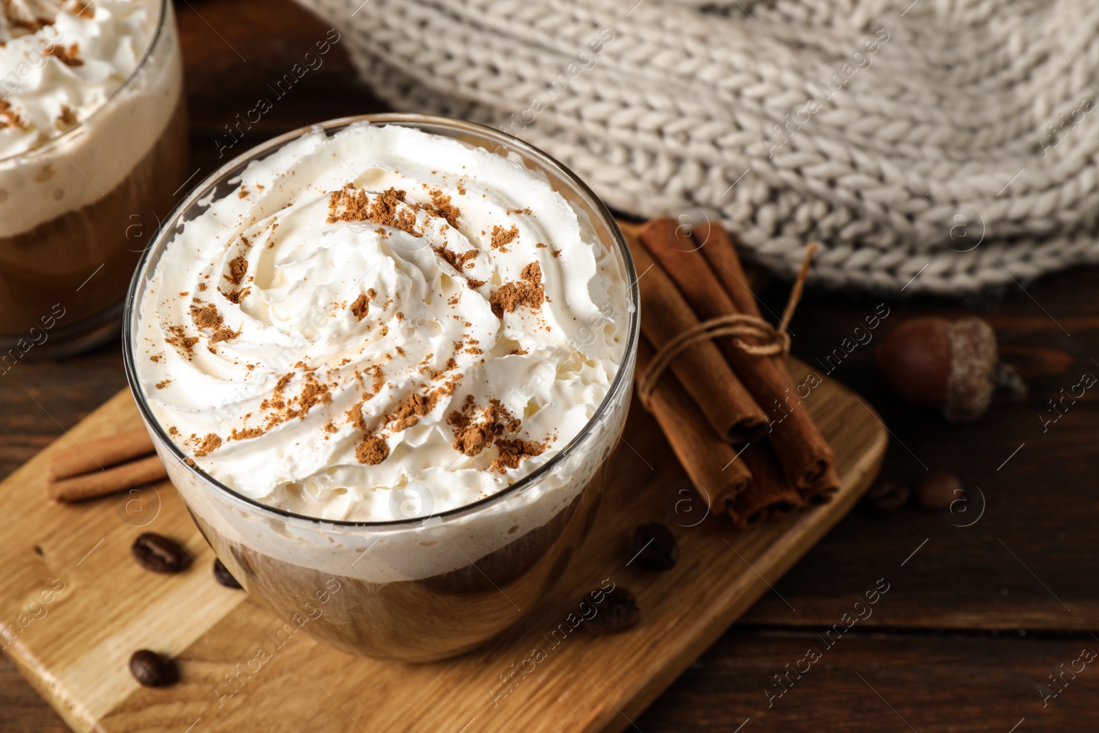 Photo of Glass with tasty pumpkin spice latte on wooden table