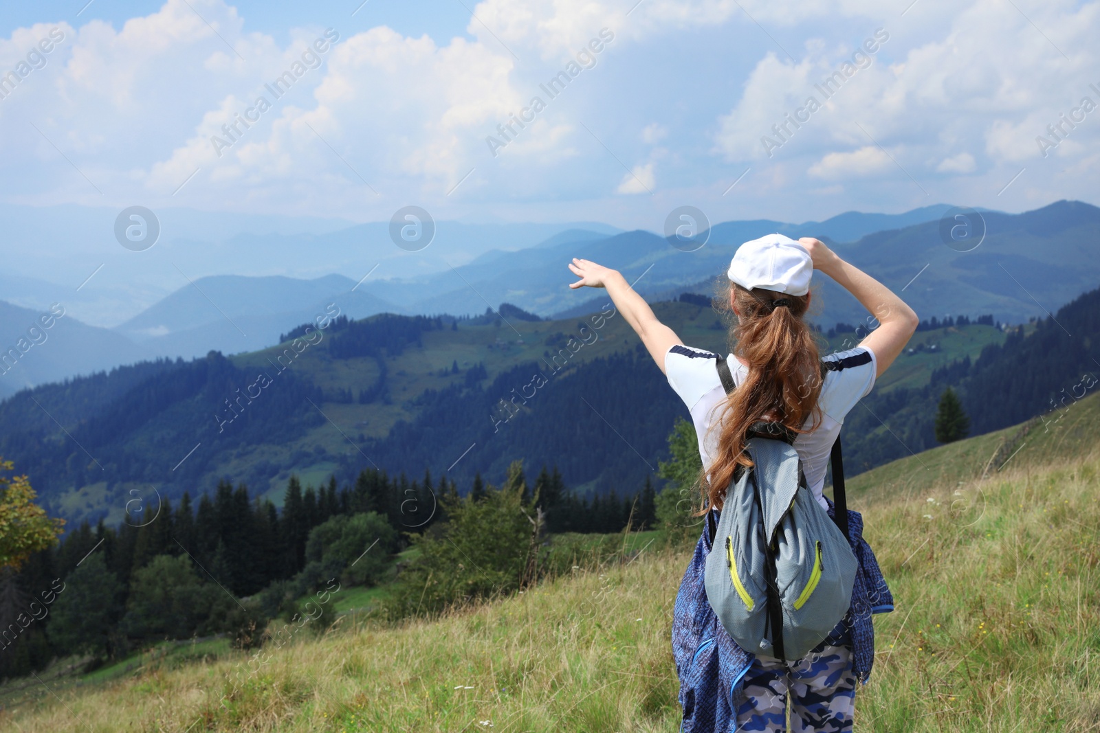 Photo of Woman with backpack in wilderness. Mountain landscape