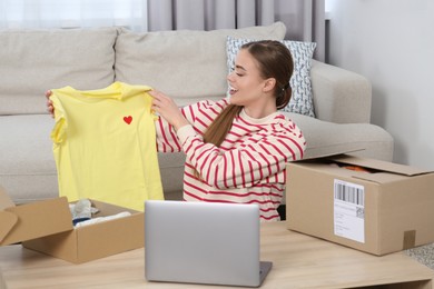 Photo of Emotional woman unpacking parcels at home. Online store