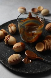 Delicious walnut shaped cookies with condensed milk on grey table, closeup