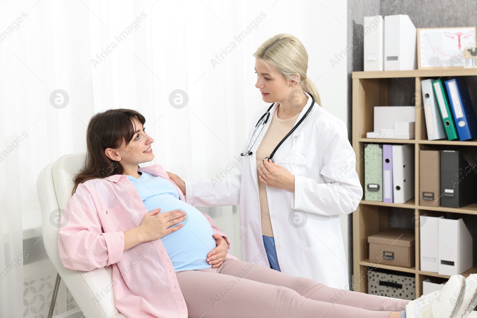 Photo of Happy pregnant woman having doctor appointment in hospital