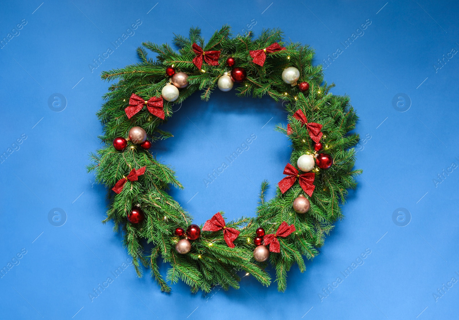 Photo of Beautiful Christmas wreath with festive decor on blue background, top view