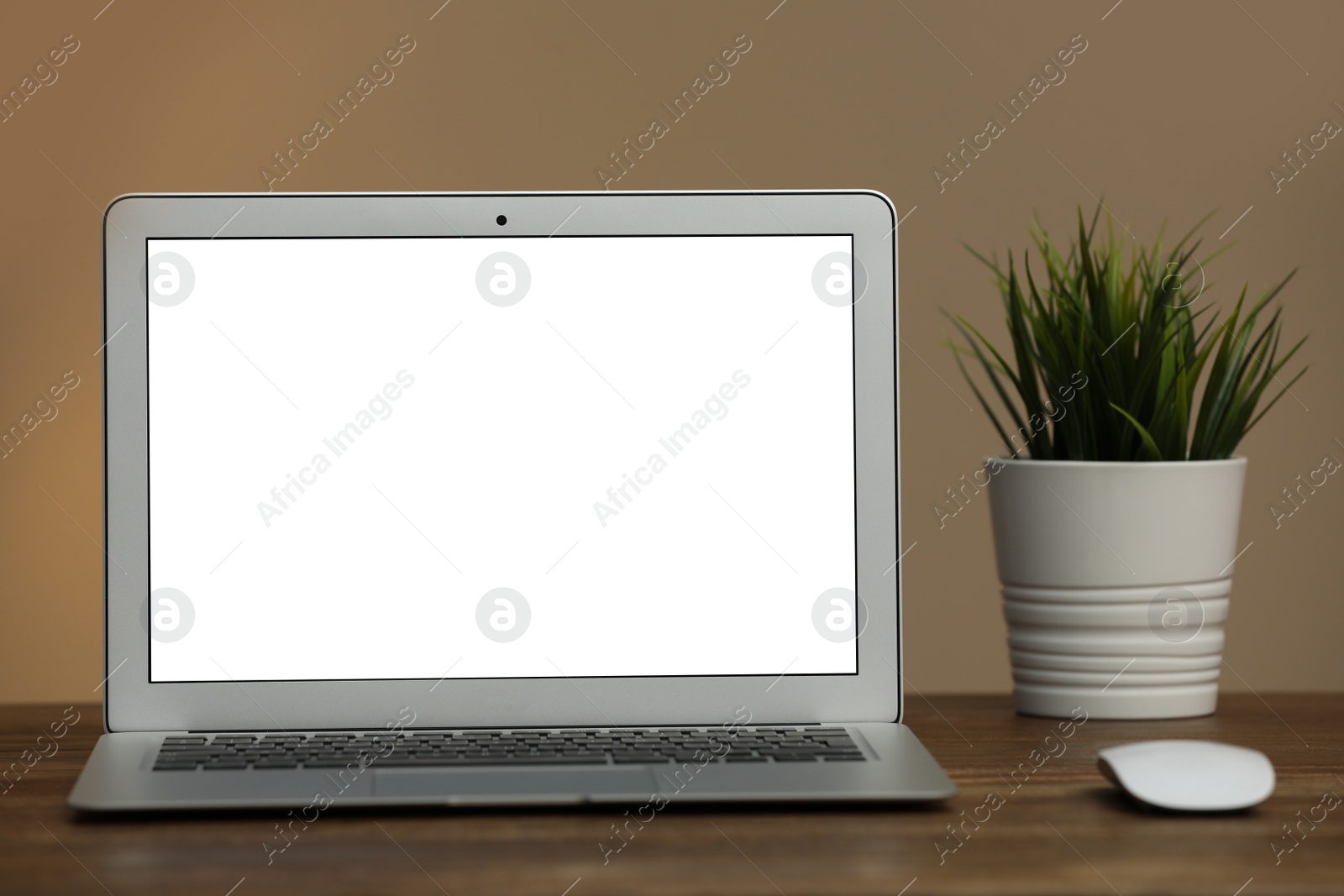 Photo of Laptop with blank screen on table indoors. Space for text