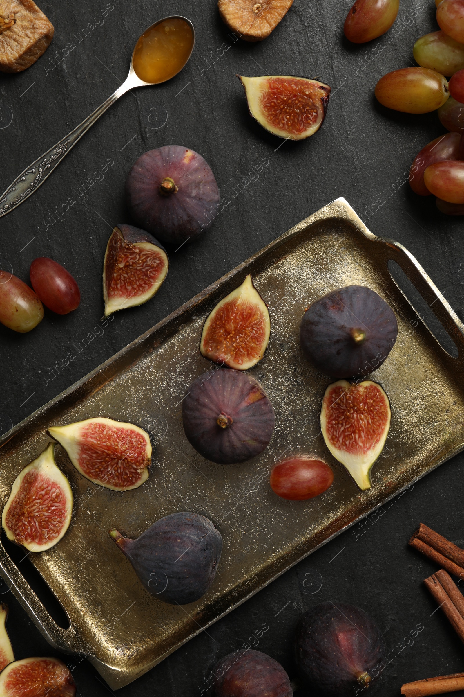 Photo of Flat lay composition with ripe figs on black slate table