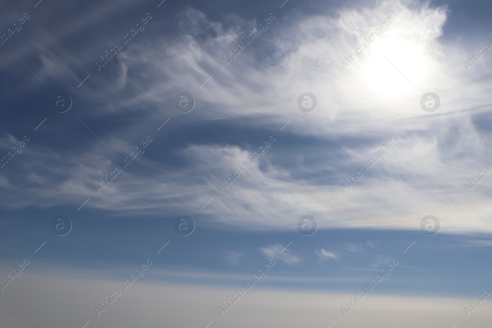 Photo of Bright sun and fluffy white clouds in blue sky