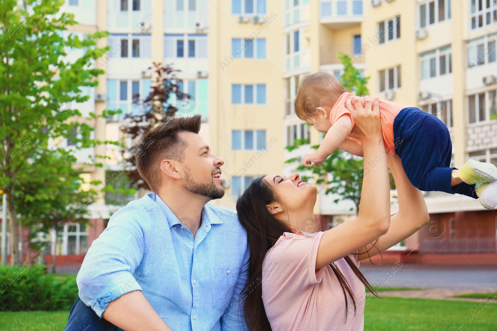 Photo of Happy family with adorable little baby outdoors