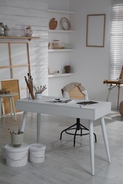Modern studio interior with artist's workplace and art supplies