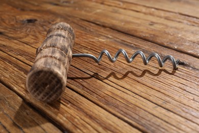 Photo of One corkscrew on wooden table, closeup view