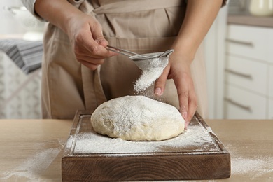 Female baker preparing bread dough at table, closeup