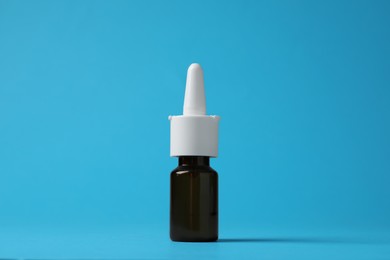 Bottle of nasal spray on light blue background