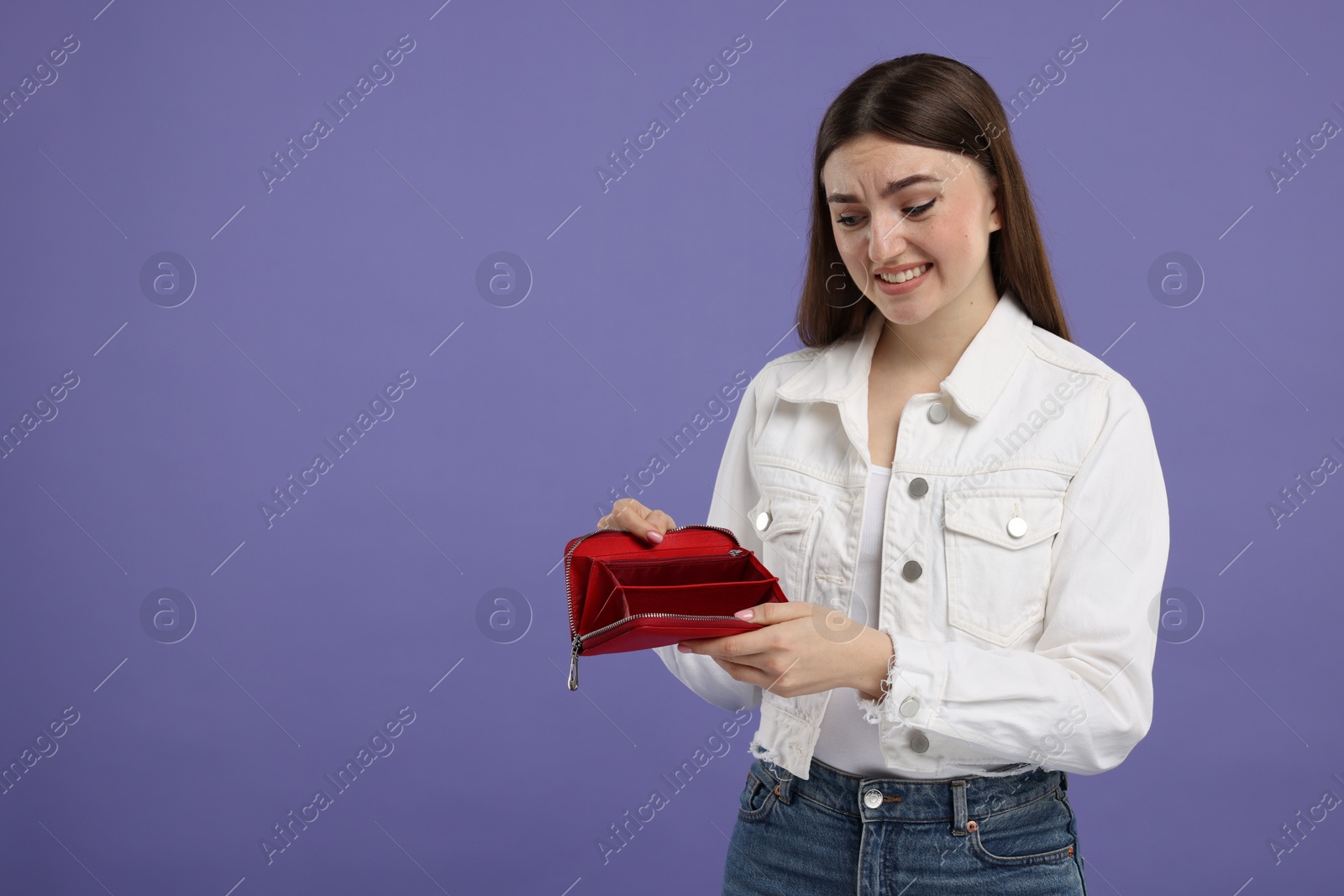 Photo of Woman showing empty wallet on purple background, space for text