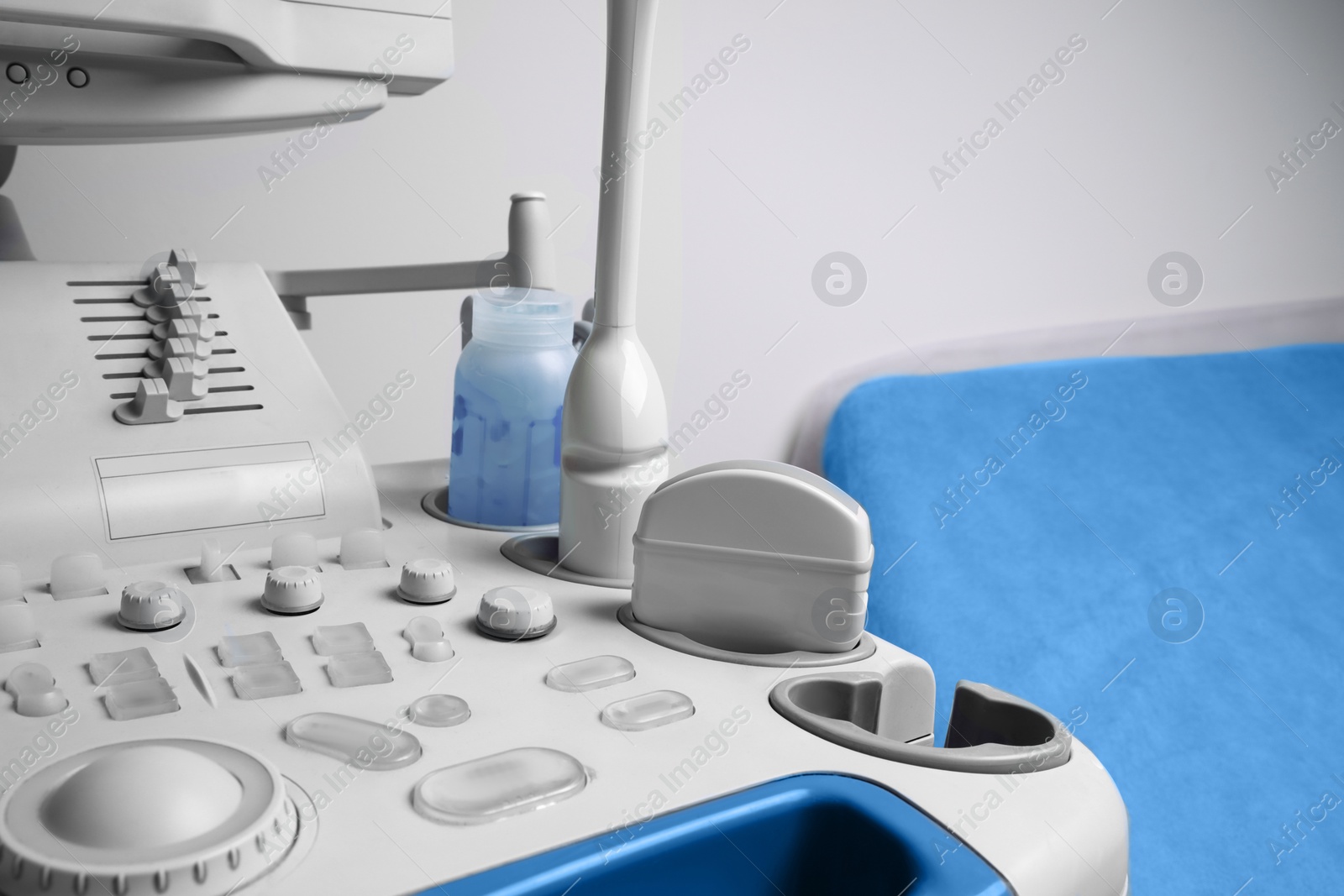 Photo of Ultrasound control panel with ultrasonic transducers and transmission gel in hospital, closeup. Medical equipment