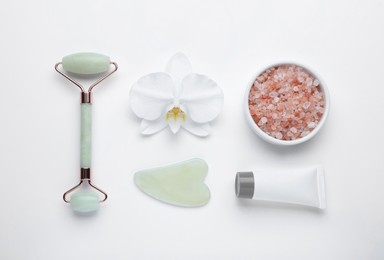 Photo of Flat lay composition with gua sha stone and face roller on white background