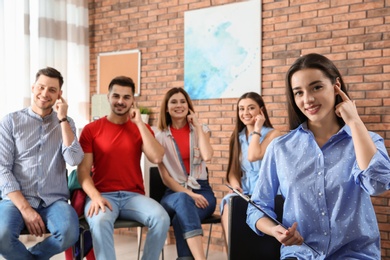 Photo of Young teacher showing sign language gesture against blurred background