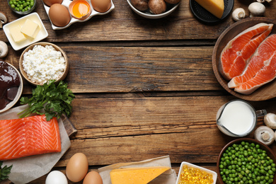 Flat lay composition with products rich in vitamin D on wooden table. Space for text