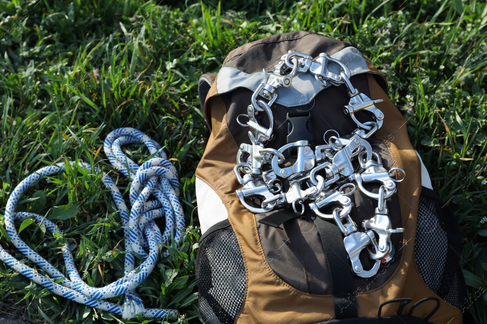 Photo of Backpack with climbing equipment on green grass outdoors