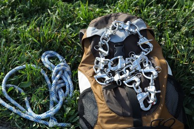 Photo of Backpack with climbing equipment on green grass outdoors