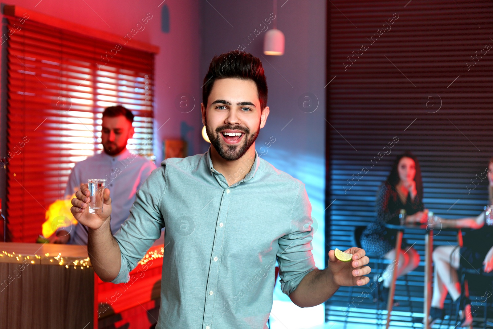 Photo of Young man with Mexican Tequila shot in bar