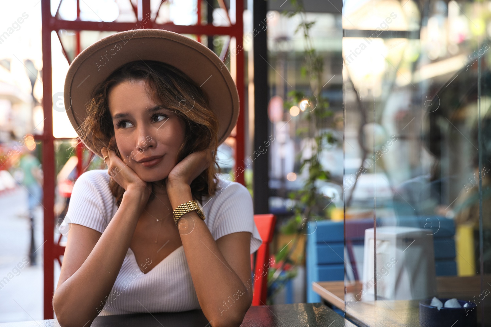 Photo of Portrait of beautiful young woman in outdoor cafe. Space for text